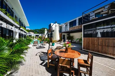 a patio with a table and chairs and an umbrella at Nomad Containers - Adults only in Tamarindo
