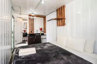 a bedroom with a large bed and a desk at Nomad Containers - Adults only in Tamarindo