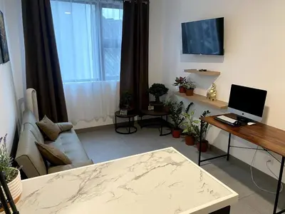 a living room with a couch and a desk with a computer at Luxury Loft in San Jose CR in San José