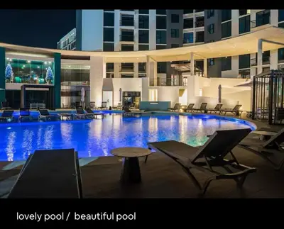 a large swimming pool with chairs and a large building at Luxury Loft in San Jose CR in San José