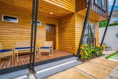 a wooden deck with two chairs and a table at Macondo Ecolodge Alpinias - Veranera in Coco