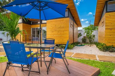 a table and chairs with an umbrella on a deck at Macondo Ecolodge Alpinias - Veranera in Coco