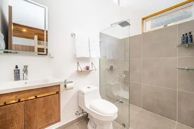 a bathroom with a toilet and a glass shower at Macondo Ecolodge in Coco