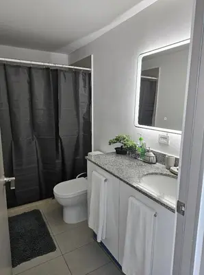 a bathroom with a sink and a toilet and a mirror at Urban Breeze iFreses, 10th floor! AC, TV and Pool in Guayabos