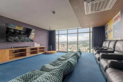 a living room with couches and a flat screen tv at Urban Breeze iFreses, 10th floor! AC, TV and Pool in Guayabos