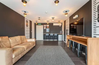 a living room with a couch and a bar at Urban Breeze iFreses, 10th floor! AC, TV and Pool in Guayabos
