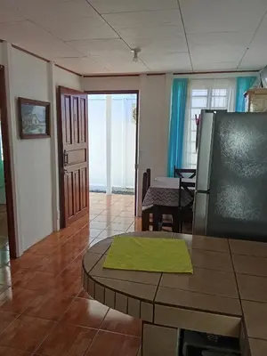 a living room with a table and a dining room at Apartamentos y Cabinas Geckos in Sardinal