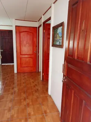 a hallway with two red doors and a tile floor at Apartamentos y Cabinas Geckos in Sardinal