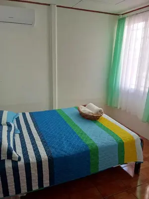 a bedroom with a bed with a colorful blanket at Apartamentos y Cabinas Geckos in Sardinal