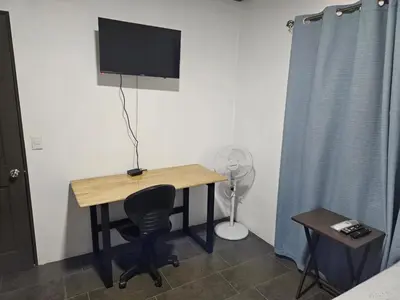 a room with a desk with a television and a chair at Paso de las Lapas in Uvita