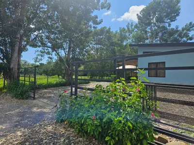 a view of a house with a fence and flowers at Paso de las Lapas in Uvita