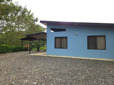 a blue house with a pavilion in the background at Paso de las Lapas in Uvita