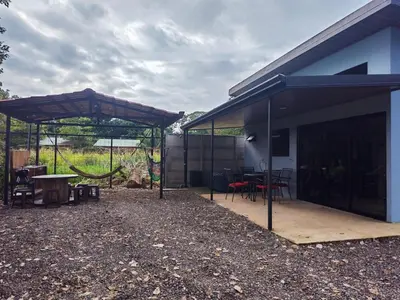 a patio with a table and a pavilion next to a house at Paso de las Lapas in Uvita