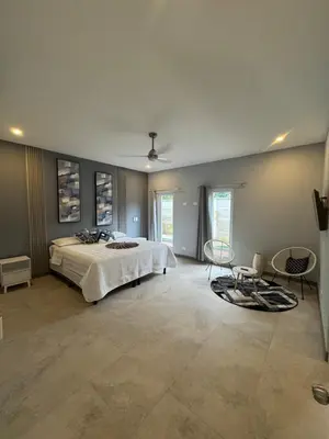 a large bedroom with a bed and two chairs at Casa fortuna 777 in Agua Azul
