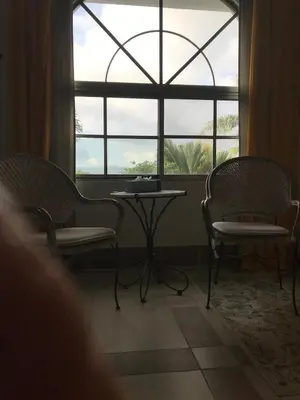 two chairs and a table in front of a window at La Serenidad in Tronadora