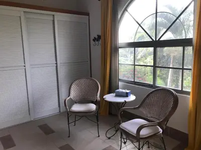 two chairs and a table in a room with a window at La Serenidad in Tronadora