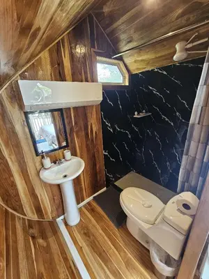 a small bathroom with a toilet and a sink at Rincón del Mar Glamping in Potrero