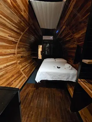 a room with a bed in a wooden cabin at Rincón del Mar Glamping in Potrero