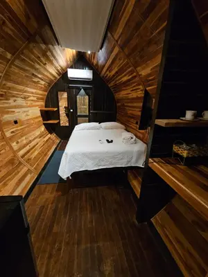 a bedroom with a bed in a wooden cabin at Rincón del Mar Glamping in Potrero