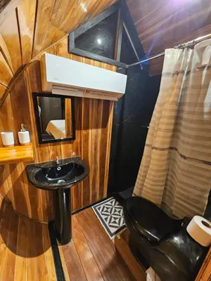 a bathroom with a black sink and a mirror at Rincón del Mar Glamping in Potrero