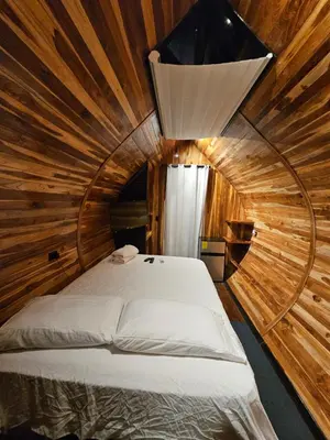 a bedroom with a bed in a wooden room at Rincón del Mar Glamping in Potrero