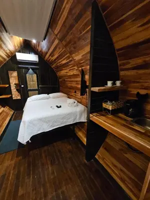 a bedroom with a bed in a wooden cabin at Rincón del Mar Glamping in Potrero