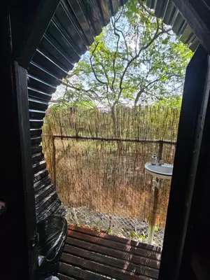 an outside view of a fence with a table and a tree at Rincón del Mar Glamping in Potrero