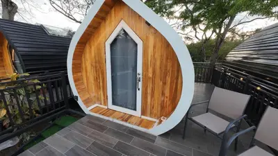 a circular house on a deck with two chairs at Rincón del Mar Glamping in Potrero