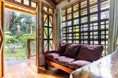 a living room with a couch in front of a large window at Cabinas Mi Sol in Uvita