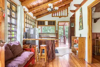 a living room with a couch and a kitchen at Cabinas Mi Sol in Uvita