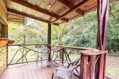 a screened in porch with chairs and a table at Cabinas Mi Sol in Uvita