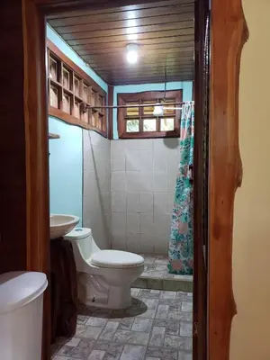 a bathroom with a toilet and a sink at Cabinas Mi Sol in Uvita