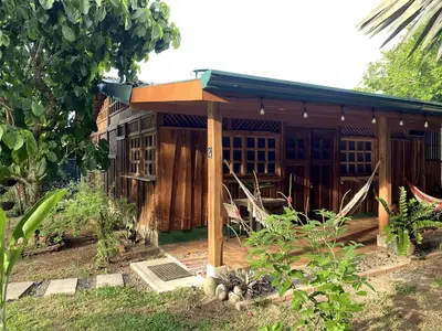 a wooden house with a roof on top of it at Cabinas Mi Sol in Uvita