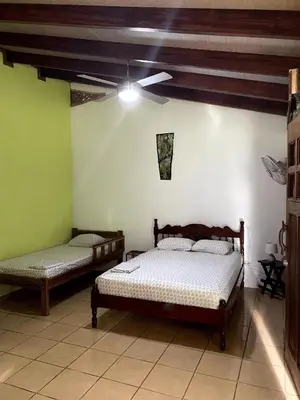 a bedroom with two beds and a ceiling fan at Cabinas Mi Sol in Uvita