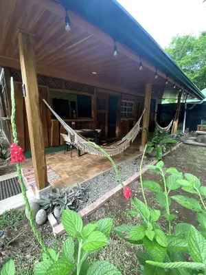 a porch of a house with a hammock at Cabinas Mi Sol in Uvita