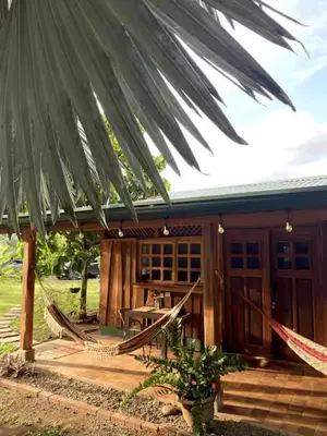 a house with hammocks in front of it at Cabinas Mi Sol in Uvita
