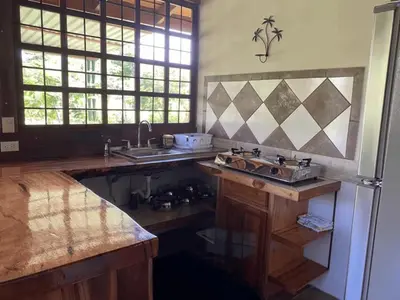 a kitchen with a sink and a refrigerator at Cabinas Mi Sol in Uvita