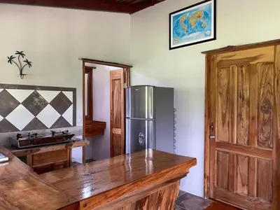 a kitchen with a stainless steel refrigerator and a wooden counter at Cabinas Mi Sol in Uvita