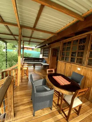 a large wooden deck with a table and chairs at Cabinas Mi Sol in Uvita