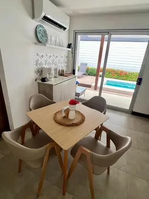 a wooden table and chairs in a room with a kitchen at Entire home with Private Pool - Coralita in Jaco, gated community, walking distance to Jaco Beach in Jacó