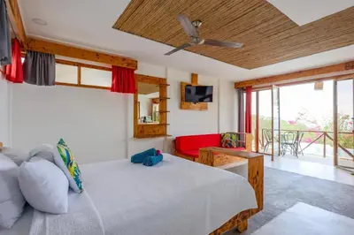 a bedroom with a bed and a living room at Ocean View Bungalows in Pital