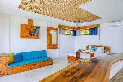 a room with a bed and a couch and a tv at Ocean View Bungalows in Pital