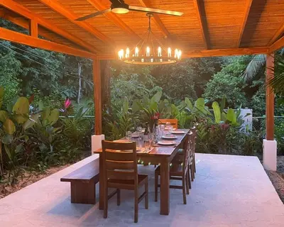 a wooden table and chairs under a wooden roof at villa colibri in Nicoya