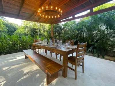 a wooden table with chairs and a chandelier at villa colibri in Nicoya