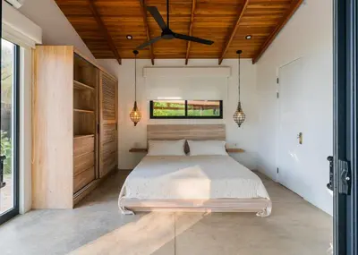 a bedroom with a bed and a ceiling fan at villa colibri in Nicoya