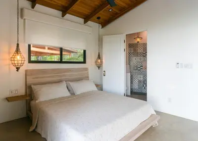 a bedroom with a white bed and two lights at villa colibri in Nicoya