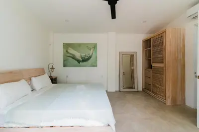 a white bedroom with a large bed and a closet at villa colibri in Nicoya