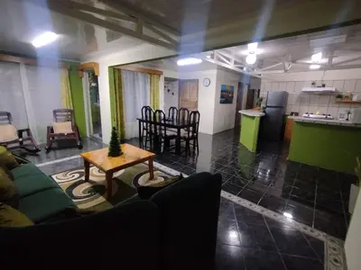 a living room with a couch and a table and a kitchen at Casa Rincón del Monte in Monteverde Costa Rica