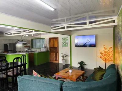 a living room with two blue couches and a kitchen at Casa Rincón del Monte in Monteverde Costa Rica