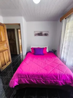 a bedroom with a large pink bed in a room at Casa Rincón del Monte in Monteverde Costa Rica